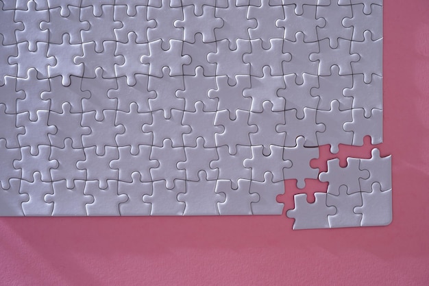 Close up jigsaw puzzle on pink background