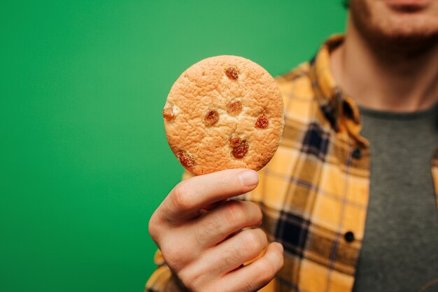 Close-up jonge man houdt koekje