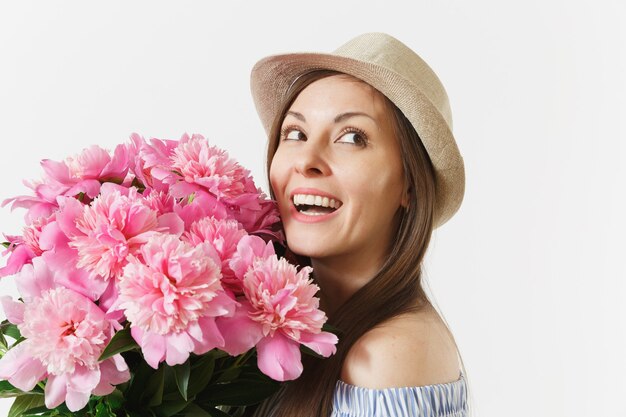 Close-up jonge tedere vrouw in blauwe jurk, hoed met boeket van roze pioenrozen bloemen geïsoleerd op een witte achtergrond. St. Valentijnsdag, Internationale Vrouwendag vakantieconcept. Reclame gebied.