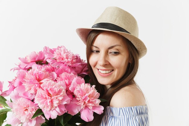 Close-up jonge tedere vrouw in blauwe jurk, hoed met boeket van roze pioenrozen bloemen geïsoleerd op een witte achtergrond. St. Valentijnsdag, Internationale Vrouwendag vakantieconcept. Reclame gebied.