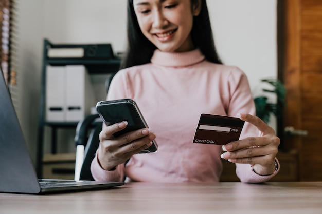 Close-up jonge vrouw maakt een online betaling voor een aankoop met creditcard Online winkelen met mobiele telefoon