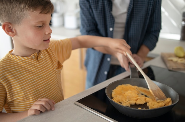 Foto close-up jongen koken omelet