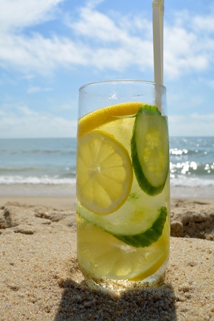 Foto close-up di succo in bicchiere sulla spiaggia