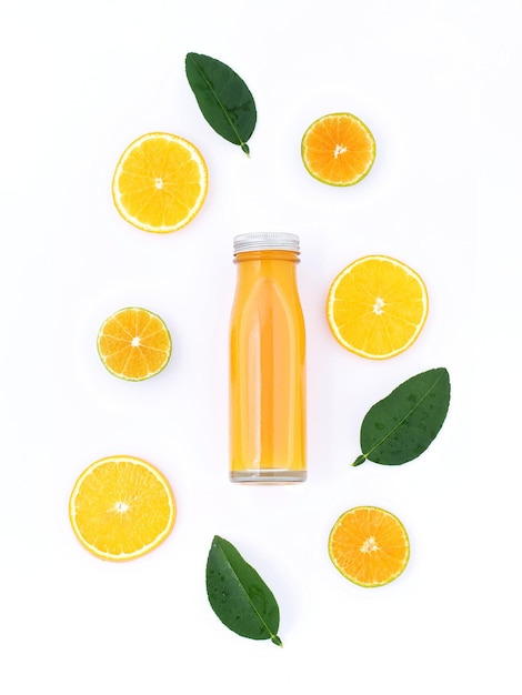 Photo close-up of juice in glass bottle amidst citrus fruits over white background