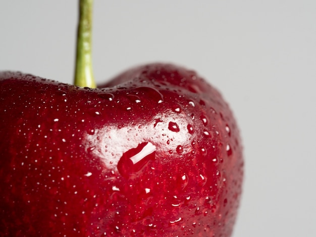Close-up of a juicy bright ripe cherry. Selective focus, blurred white background