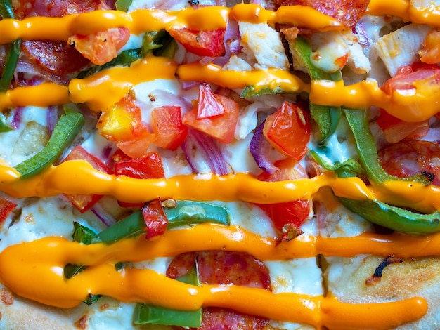 Close-up of a juicy, delicious pizza drizzled with orange hot sauce. Traditional Italian dish