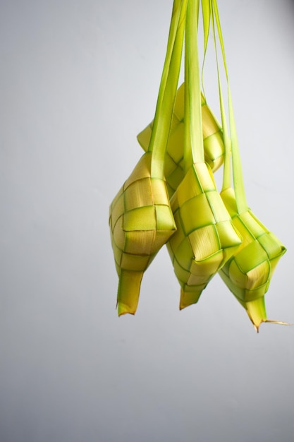 Photo close up ketupat and copy space with isolated white background traditional culture in indonesia wel