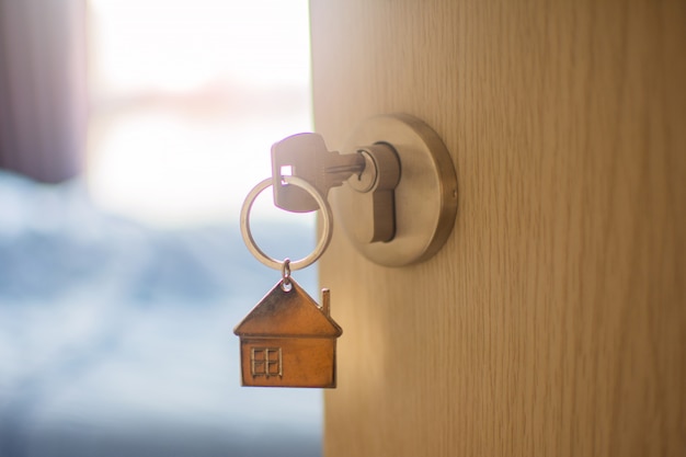 Close up key on the door with morning light, personal loan . subject is blurry.