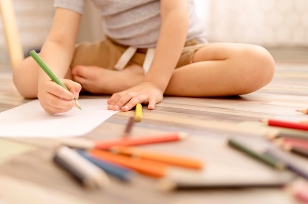 Close-up kid drawing on floor