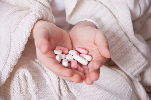 Close up of kid hand holding medicine pills