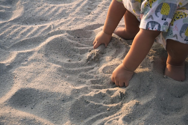 Photo close up of kid hands digging on the beach sand