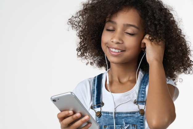 Close up of kid listening music and enjoying with earphones on white isolated background