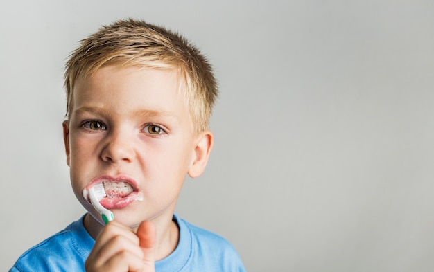 Foto spazzolatura di denti del bambino del primo piano