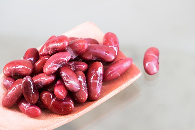 Close-up of kidney beans in spoon on white background