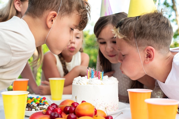 Close up kids blowing out the candles together