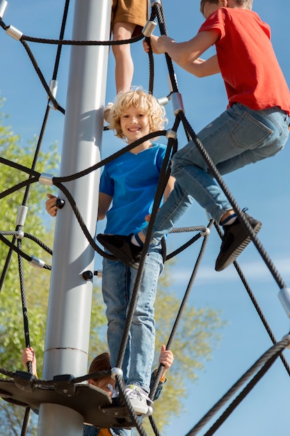 Photo close up kids climbing rope outdoors