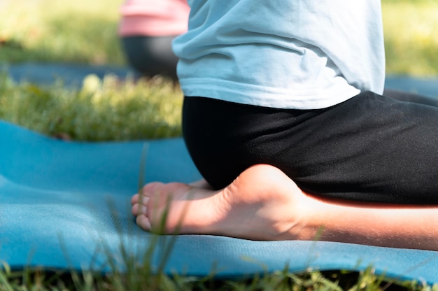 Foto close-up kind zittend op yogamat