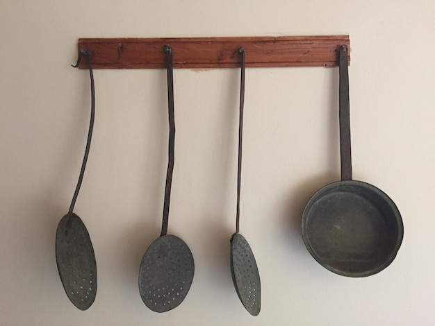 Foto close-up di utensili da cucina appesi al legno