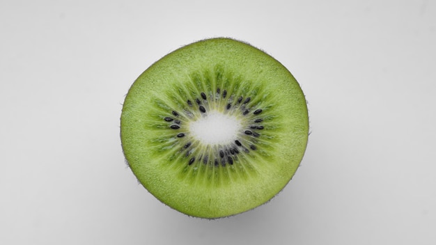 白い背景の上にキウイの切片をクローズアップ