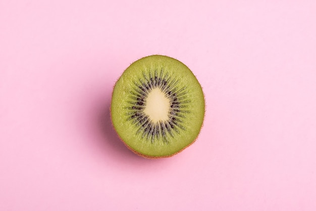 Close-up of a kiwi sliced on half on pink