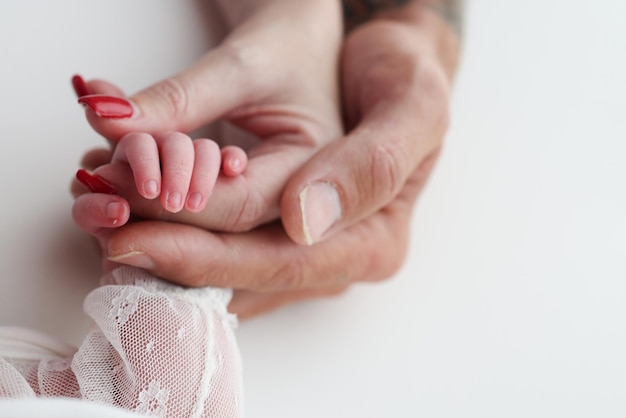 Close-up kleine hand van het kind en de handpalm van moeder en vader De pasgeboren baby heeft een stevige greep op de vinger van de ouders na de geboorte Een pasgeborene houdt vast aan de vingers van de moeder en de vader