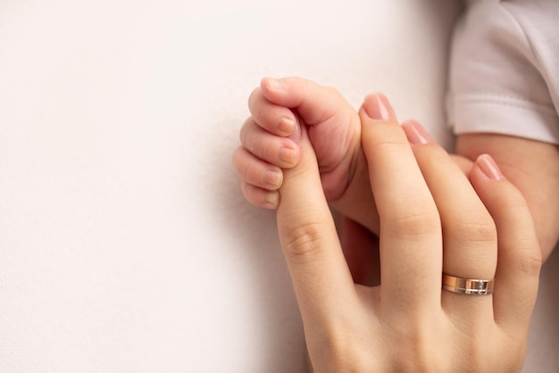 Close-up kleine hand van kind en palm van moeder en vader De pasgeboren baby heeft na de geboorte een stevige greep op de vinger van de ouder39s Een pasgeboren houdt vast aan de vinger van de moeder39s vader39s