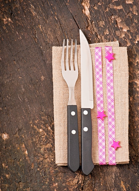 Close up of a knife and fork on a white plate with napkin