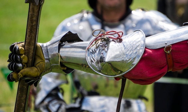 Close up of a knights armoured hand holding a weapon