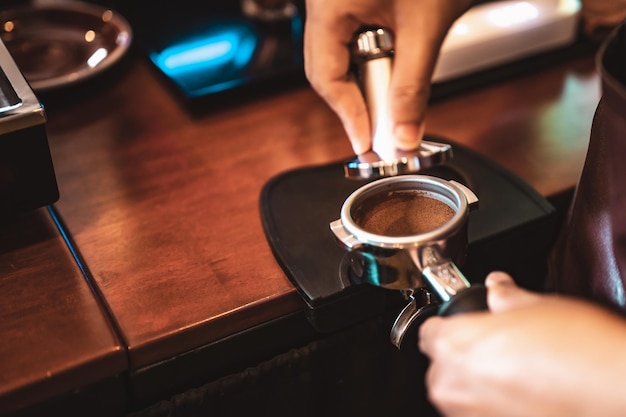 Close-up koffiezetapparaat dat professioneel koffie zet door barista met een diep wit glas in het avondzonlicht. koffie, extractie, diep, machine, maken, barista-concept.