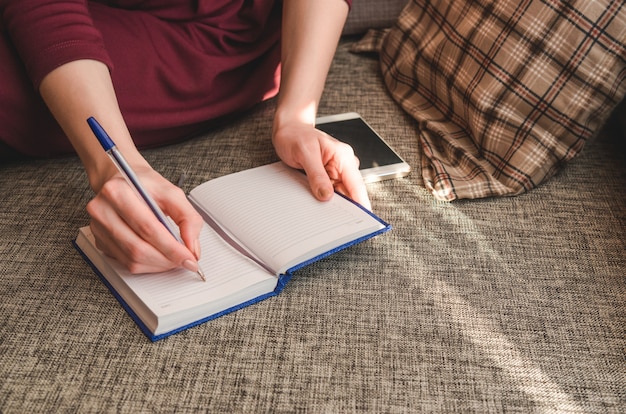 Close up of lady's hand writing to her diary