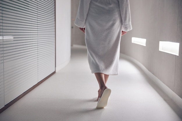 Close up on a lady in slippers walking along the corridor in a spa salon