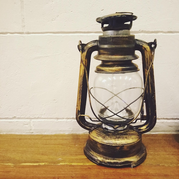 Photo close-up of lantern on table against wall