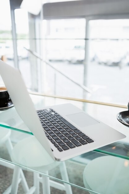 Primo piano di un computer portatile sul tavolo di vetro