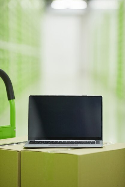 Close-up of laptop on the stack of boxes for online delivery