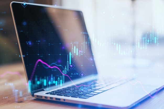 close up of laptop with glowing forex chart on blurry background fintech digital transformation and finance concept double exposure