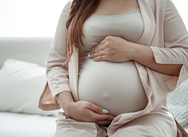 Photo close-up of a large belly of a woman in the last months of pregnancy.