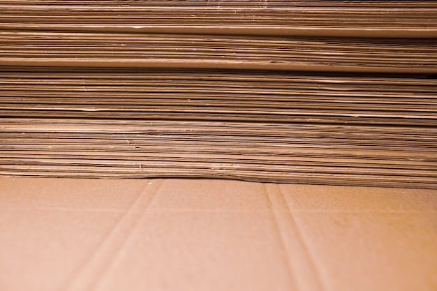 Close-up large cardboard piles lie on top of each other in a warehouse. Concept of storage of things and environmentally friendly material. Renewable material concept