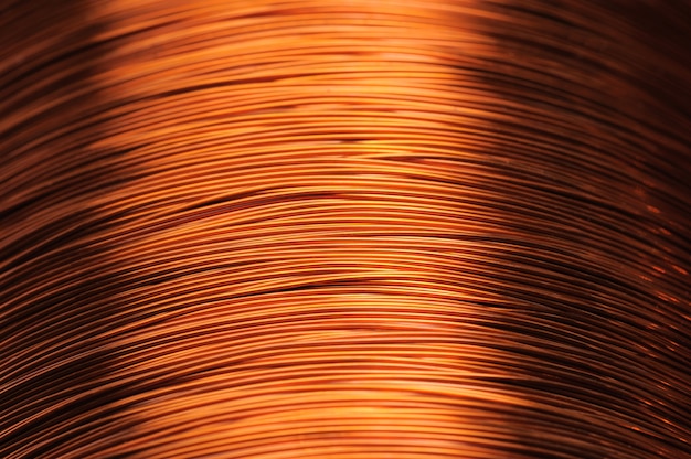 Close-up large coil of thin copper wire in the production of technical parts.