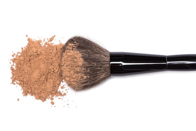 Photo close-up of large makeup brush with loose cosmetic powder on white background