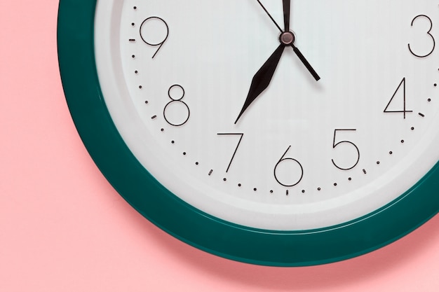 Close up of large office clock on pink
