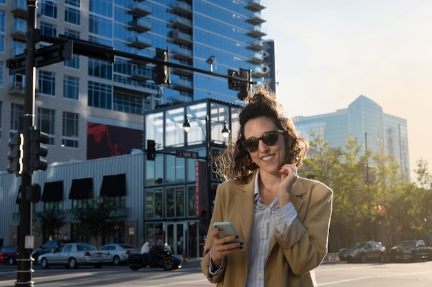 Close-up of latina woman in the united states smiling looking at the camera while holding her smartphone, copy space