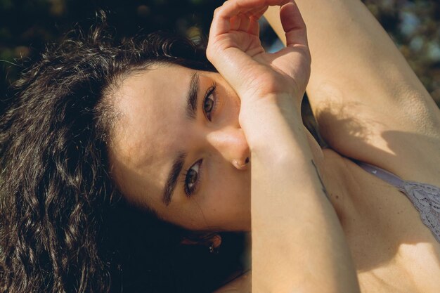 Close up of latina woman39s face with honey eyes looks at camera outside connecting with nature