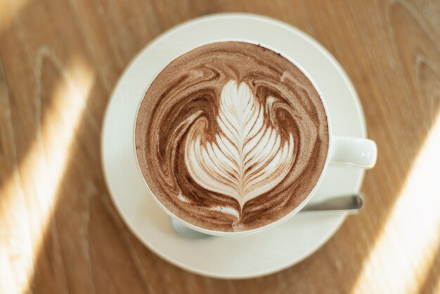 Close up of latte art hot coffee on wood table