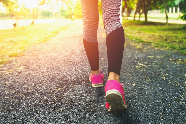 Close up leg woman running with sunset