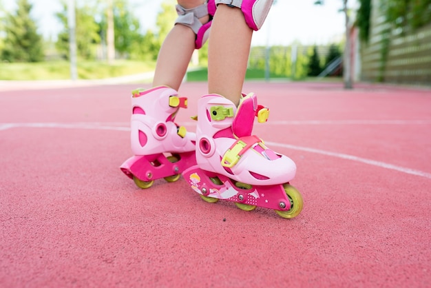 公園でスケートをしている女の子のローラースケートのクローズアップ脚