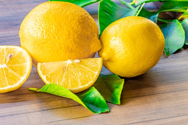 Close up of lemon and green leaves on rustic wooden table