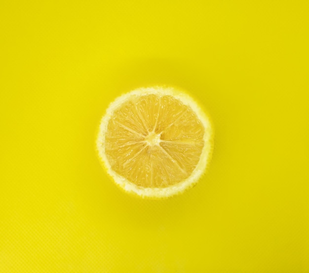 Close-up of lemon slice on yellow background isolated