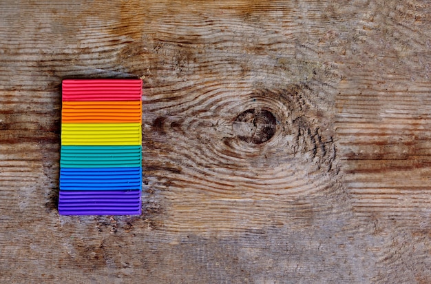 Foto primo piano della bandiera lgbt sullo sfondo in legno chiaro. colori dell'arcobaleno lgbt dalla plastilina