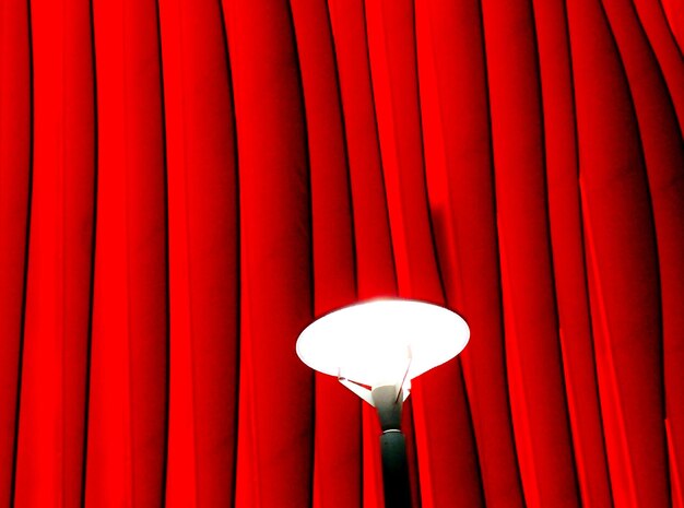 Photo close-up of light against red curtain