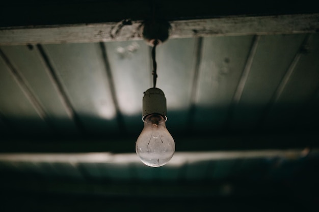 Photo close-up of light bulb hanging from ceiling